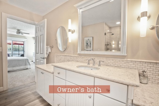 ensuite bathroom featuring a ceiling fan, a tile shower, connected bathroom, wood finished floors, and tasteful backsplash