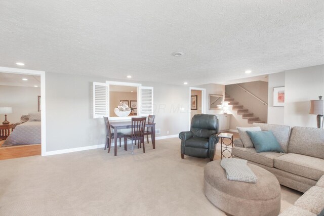 living room featuring light carpet, stairs, baseboards, and recessed lighting