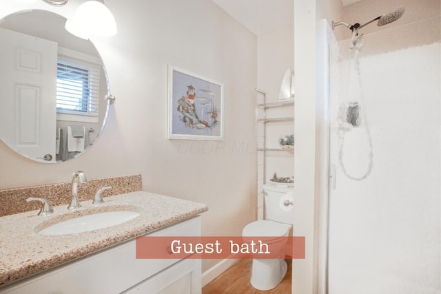 full bath with walk in shower, toilet, wood finished floors, vanity, and baseboards