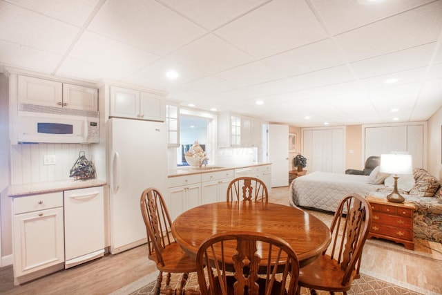 dining room featuring light wood-style floors and a paneled ceiling