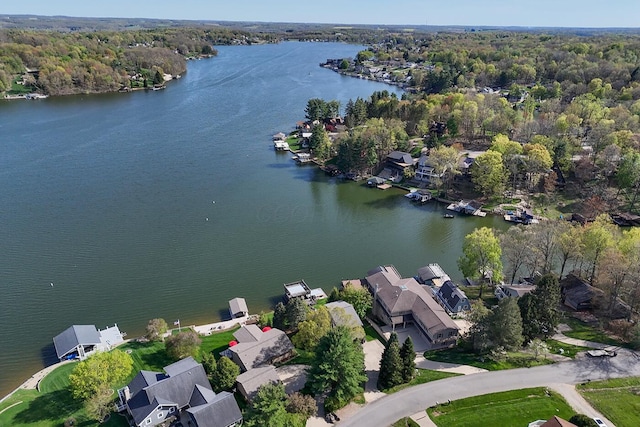 birds eye view of property with a wooded view, a water view, and a residential view