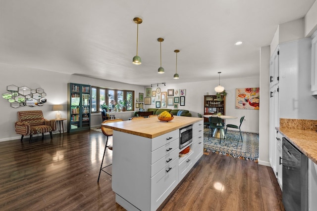 746 Ronson Ave, Columbus, OH 43230 - kitchen with dishwasher, wooden counters, open floor plan, stainless steel microwave, and a breakfast bar area