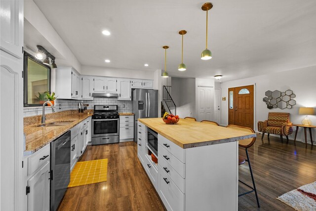 746 Ronson Ave, Columbus, OH 43230 - kitchen featuring stainless steel appliances, a sink, butcher block counters, a kitchen bar, and white cabinets