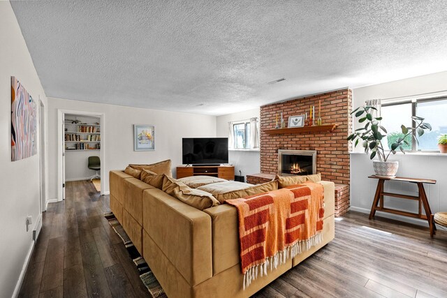746 Ronson Ave, Columbus, OH 43230 - living room featuring dark wood-style floors, a textured ceiling, baseboards, and a brick fireplace