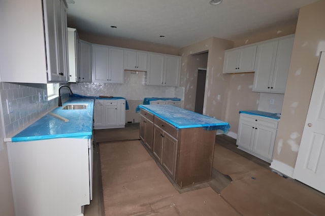 1012 Heimat Haus Dr N, Grove City, OH 43123 - kitchen with a sink, a kitchen island, decorative backsplash, and white cabinetry