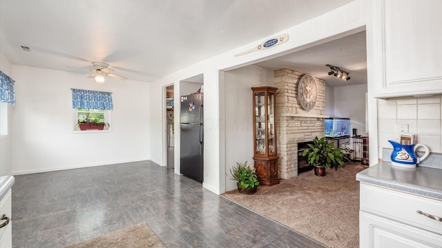14672 Township Rd Unit 1062, Thornville, OH 43076 - kitchen with freestanding refrigerator, a ceiling fan, a fireplace, white cabinetry, and baseboards