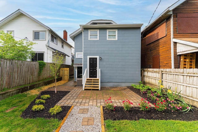 146 E Woodrow Ave, Columbus, OH 43207 - rear view of house with entry steps, a fenced backyard, and a patio