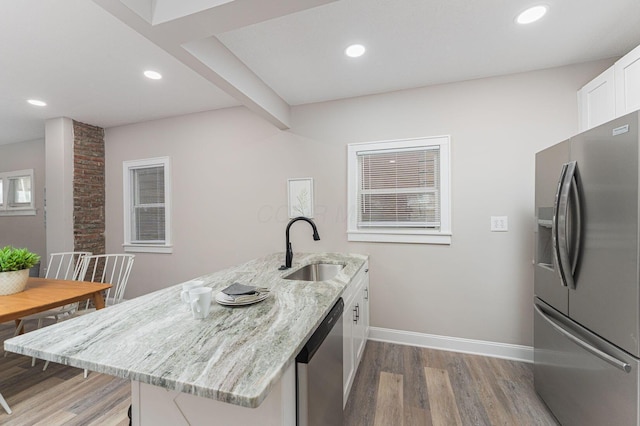 146 E Woodrow Ave, Columbus, OH 43207 - kitchen with stainless steel appliances, a sink, light wood finished floors, light stone countertops, and recessed lighting