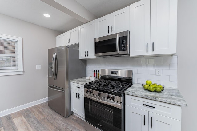 146 E Woodrow Ave, Columbus, OH 43207 - kitchen featuring appliances with stainless steel finishes, light wood-style flooring, decorative backsplash, white cabinets, and recessed lighting
