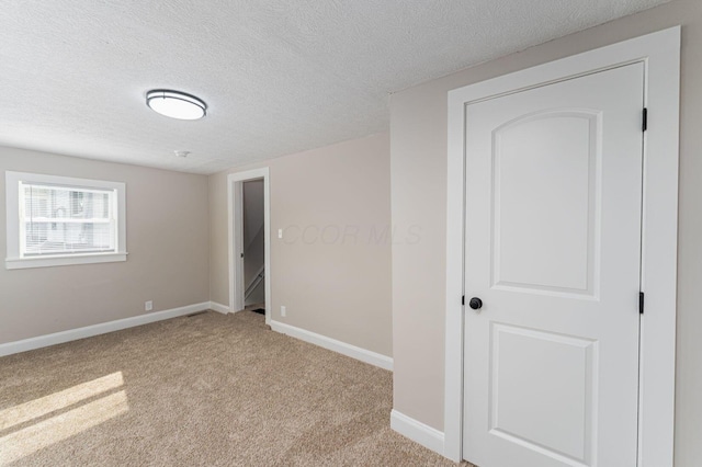 146 E Woodrow Ave, Columbus, OH 43207 - unfurnished bedroom featuring light carpet, baseboards, and a textured ceiling