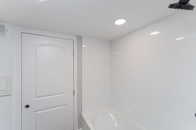 146 E Woodrow Ave, Columbus, OH 43207 - bathroom featuring a textured ceiling and washtub / shower combination