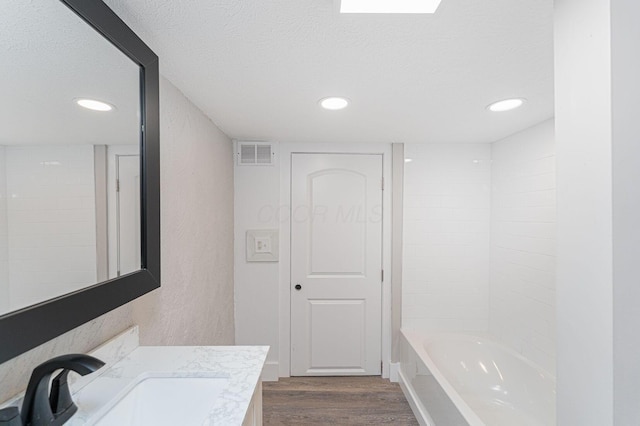 146 E Woodrow Ave, Columbus, OH 43207 - bathroom with wood finished floors, a textured ceiling, vanity, recessed lighting, and shower / bathtub combination