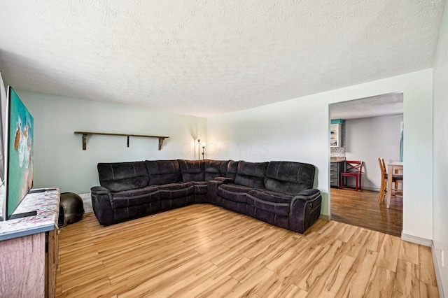 living area featuring light wood-style floors and a textured ceiling