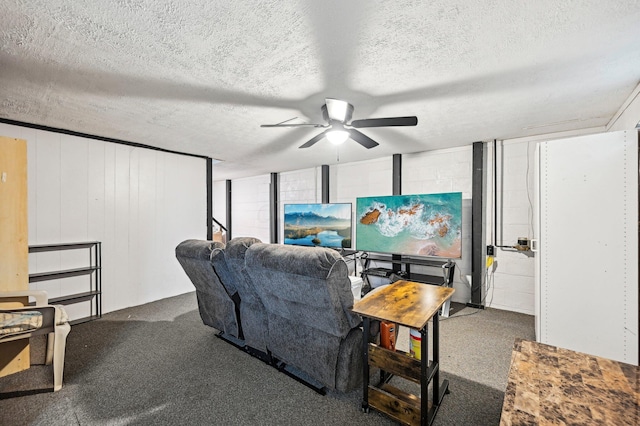 living area featuring a ceiling fan, a textured ceiling, and dark colored carpet