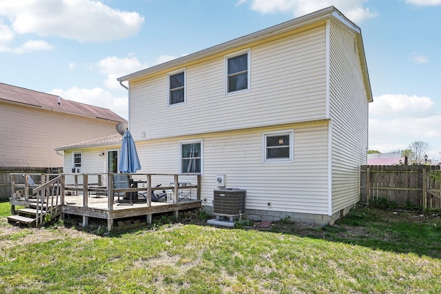 rear view of house with fence, central AC unit, a yard, and a deck