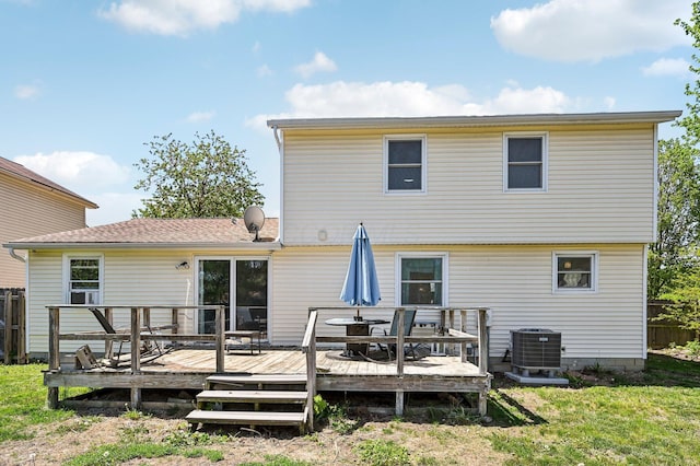 back of property featuring fence, a yard, a wooden deck, and cooling unit