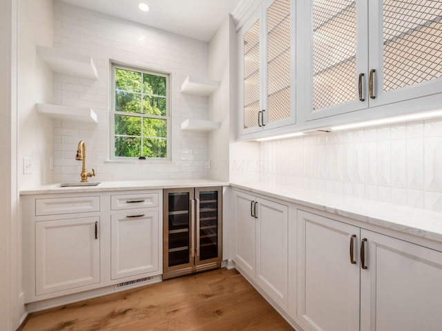 2355 Farleigh Rd, Columbus, OH 43221 - indoor wet bar featuring beverage cooler, backsplash, light wood-style flooring, and recessed lighting