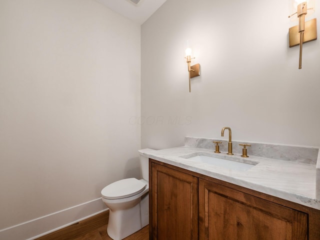 2355 Farleigh Rd, Columbus, OH 43221 - half bathroom featuring vanity, toilet, wood finished floors, and baseboards