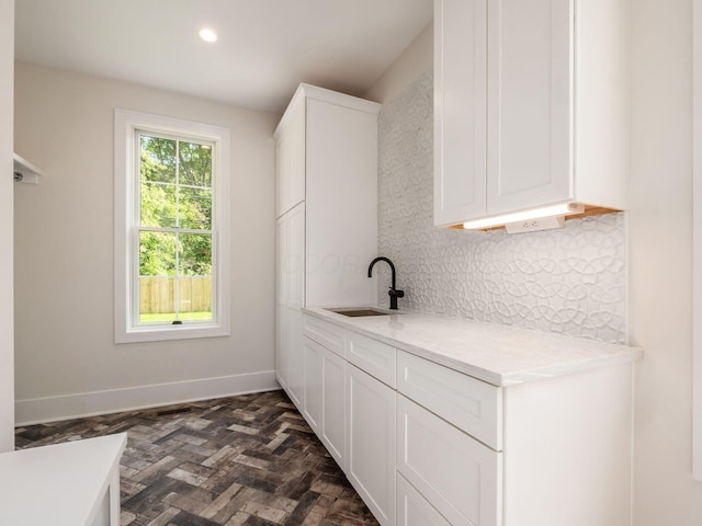 2355 Farleigh Rd, Columbus, OH 43221 - kitchen with a sink, decorative backsplash, light countertops, white cabinets, and baseboards