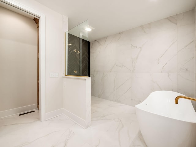 2355 Farleigh Rd, Columbus, OH 43221 - bathroom featuring marble tiled floors, a freestanding bath, and baseboards