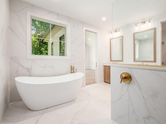 2355 Farleigh Rd, Columbus, OH 43221 - full bath with marble tiled floors, double vanity, a freestanding tub, recessed lighting, and tile walls