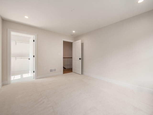 2355 Farleigh Rd, Columbus, OH 43221 - unfurnished bedroom featuring recessed lighting, baseboards, light carpet, and a walk in closet