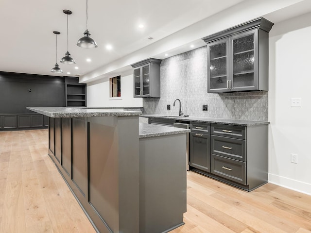 2355 Farleigh Rd, Columbus, OH 43221 - kitchen with a sink, backsplash, light wood-style floors, a center island, and glass insert cabinets