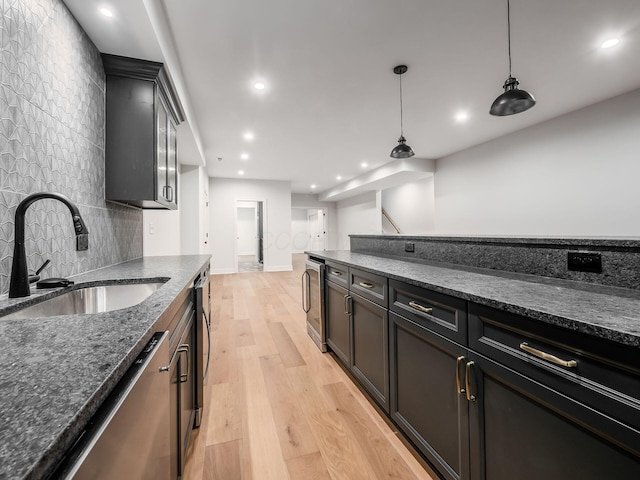 2355 Farleigh Rd, Columbus, OH 43221 - kitchen featuring a sink, stainless steel dishwasher, dark stone counters, decorative backsplash, and light wood-style flooring