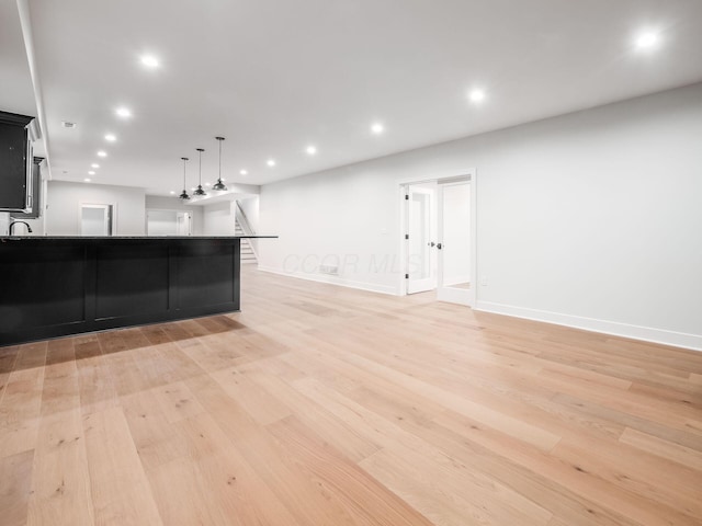 2355 Farleigh Rd, Columbus, OH 43221 - unfurnished living room with light wood-type flooring, baseboards, recessed lighting, and a sink