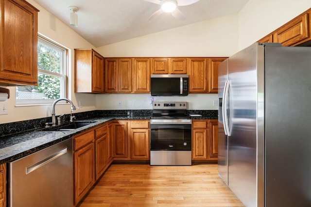 4977 Softwood Ct, Westerville, OH 43081 - kitchen featuring appliances with stainless steel finishes, a sink, vaulted ceiling, and brown cabinets