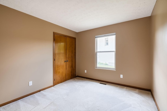 4977 Softwood Ct, Westerville, OH 43081 - empty room featuring light colored carpet, baseboards, and a textured ceiling