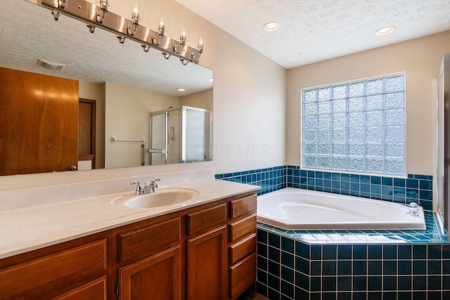 4977 Softwood Ct, Westerville, OH 43081 - full bathroom featuring a textured ceiling, vanity, a bath, a stall shower, and recessed lighting