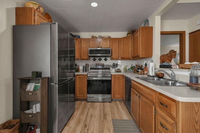 1324 Hillview Cir W, Newark, OH 43055 - kitchen with brown cabinets, appliances with stainless steel finishes, a sink, light countertops, and light wood-type flooring