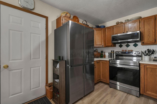 1324 Hillview Cir W, Newark, OH 43055 - kitchen with brown cabinets, stainless steel appliances, light wood-style floors, and light countertops
