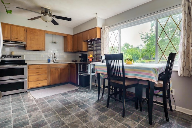 109 Williams Rd, Columbus, OH 43207 - kitchen with double oven range, under cabinet range hood, backsplash, light countertops, and ceiling fan
