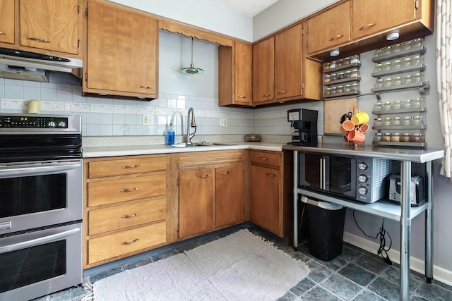 109 Williams Rd, Columbus, OH 43207 - kitchen with range with two ovens, under cabinet range hood, a sink, light countertops, and tasteful backsplash