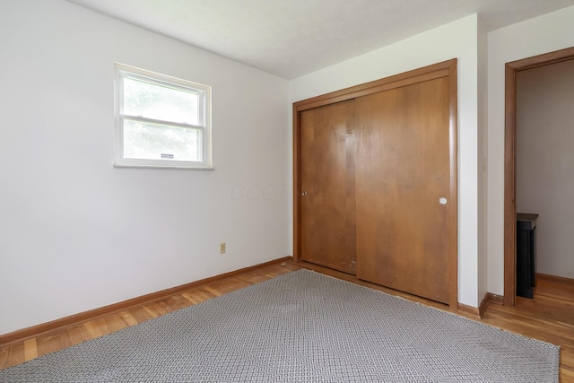 109 Williams Rd, Columbus, OH 43207 - unfurnished bedroom with baseboards, light wood-style floors, and a closet