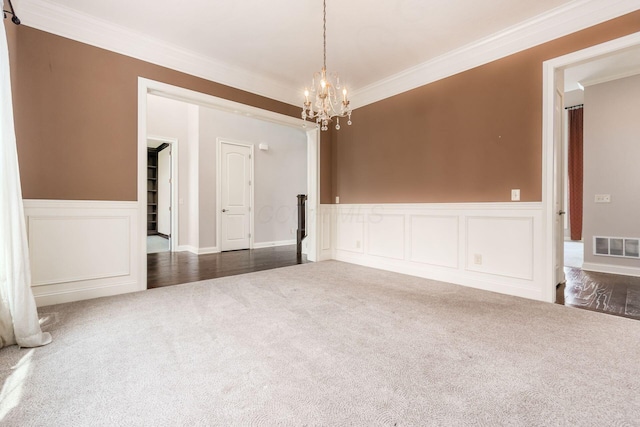 1393 Kearney Way, Delaware, OH 43015 - empty room featuring dark colored carpet, ornamental molding, a chandelier, a wainscoted wall, and a decorative wall