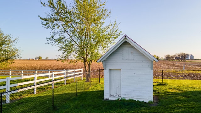 view of shed featuring fence and a rural view