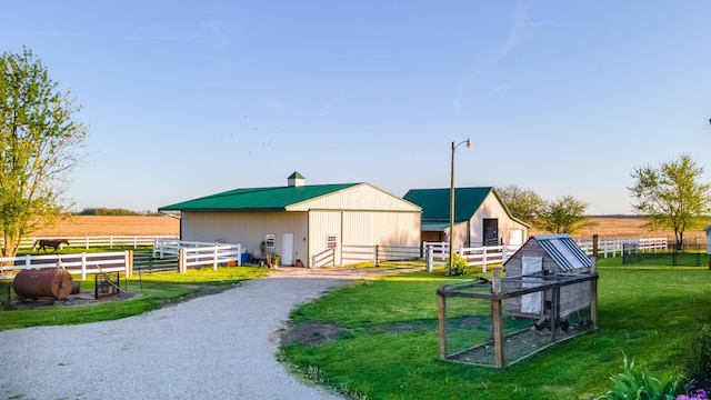 rear view of property featuring an outdoor structure, an exterior structure, and a rural view