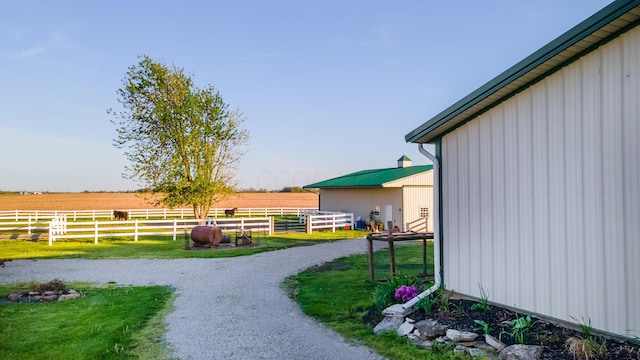 view of yard with fence and a rural view