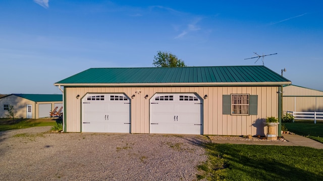 detached garage featuring fence and driveway