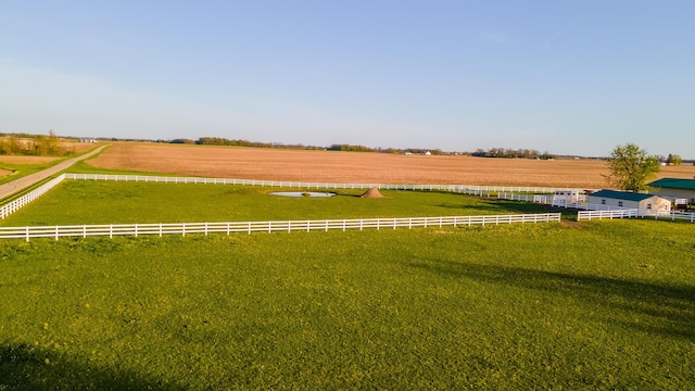 view of yard with fence and a rural view