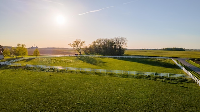 view of community with a rural view and fence