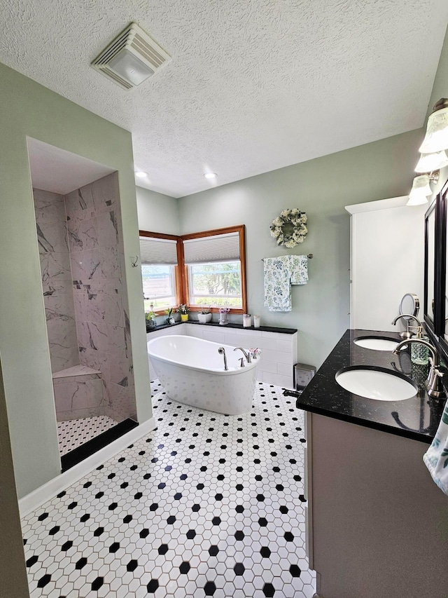 3851 Snow Hill Rd SW, Washington Court House, OH 43160 - bathroom featuring double vanity, a soaking tub, walk in shower, and a textured ceiling