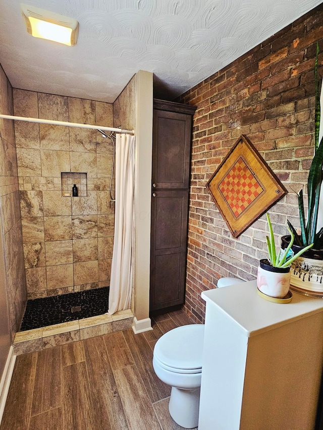 3851 Snow Hill Rd SW, Washington Court House, OH 43160 - bathroom with toilet, wood finished floors, a stall shower, and brick wall