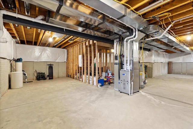 unfinished below grade area featuring heating unit and brick wall