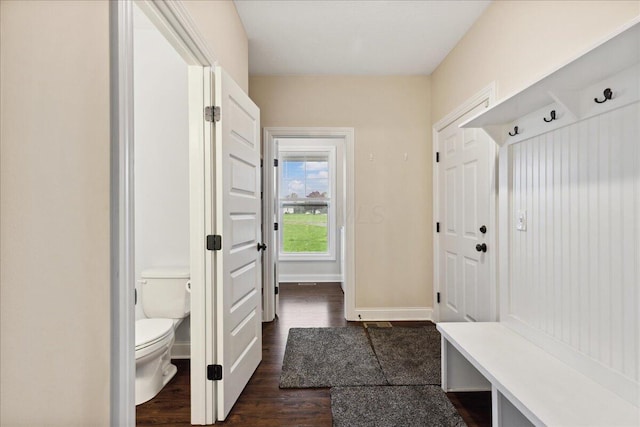 mudroom with dark wood-style flooring and baseboards