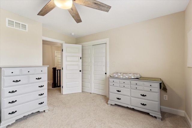 bedroom featuring light carpet, a closet, baseboards, and ceiling fan