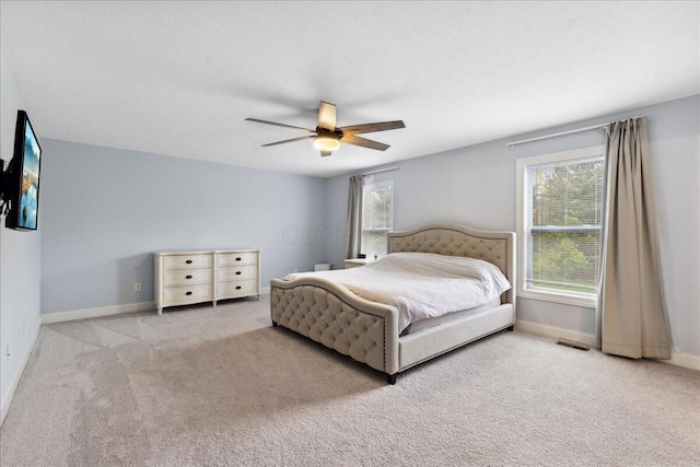 carpeted bedroom featuring baseboards and a ceiling fan
